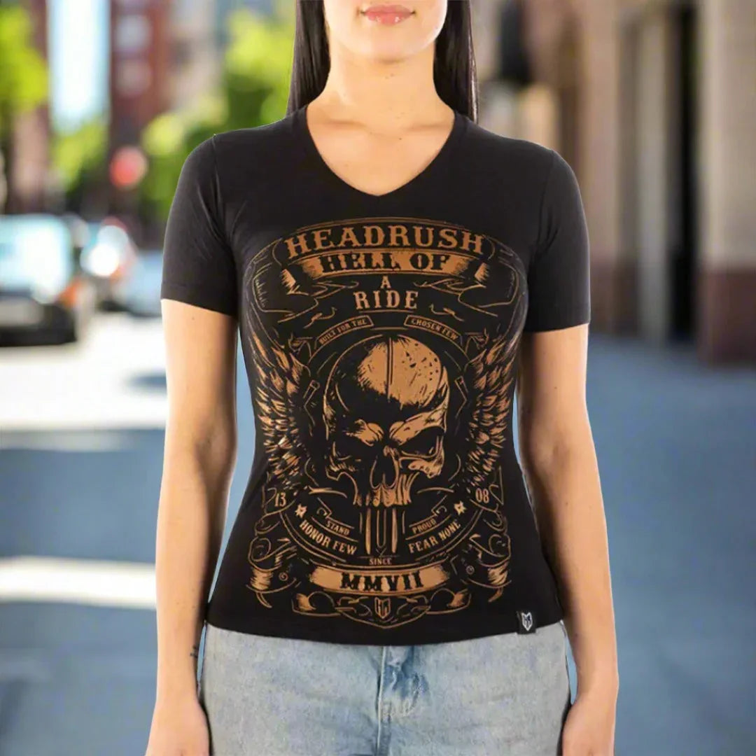 Woman wearing a black vintage V-neck T-shirt with gold skull and wings graphic, street background