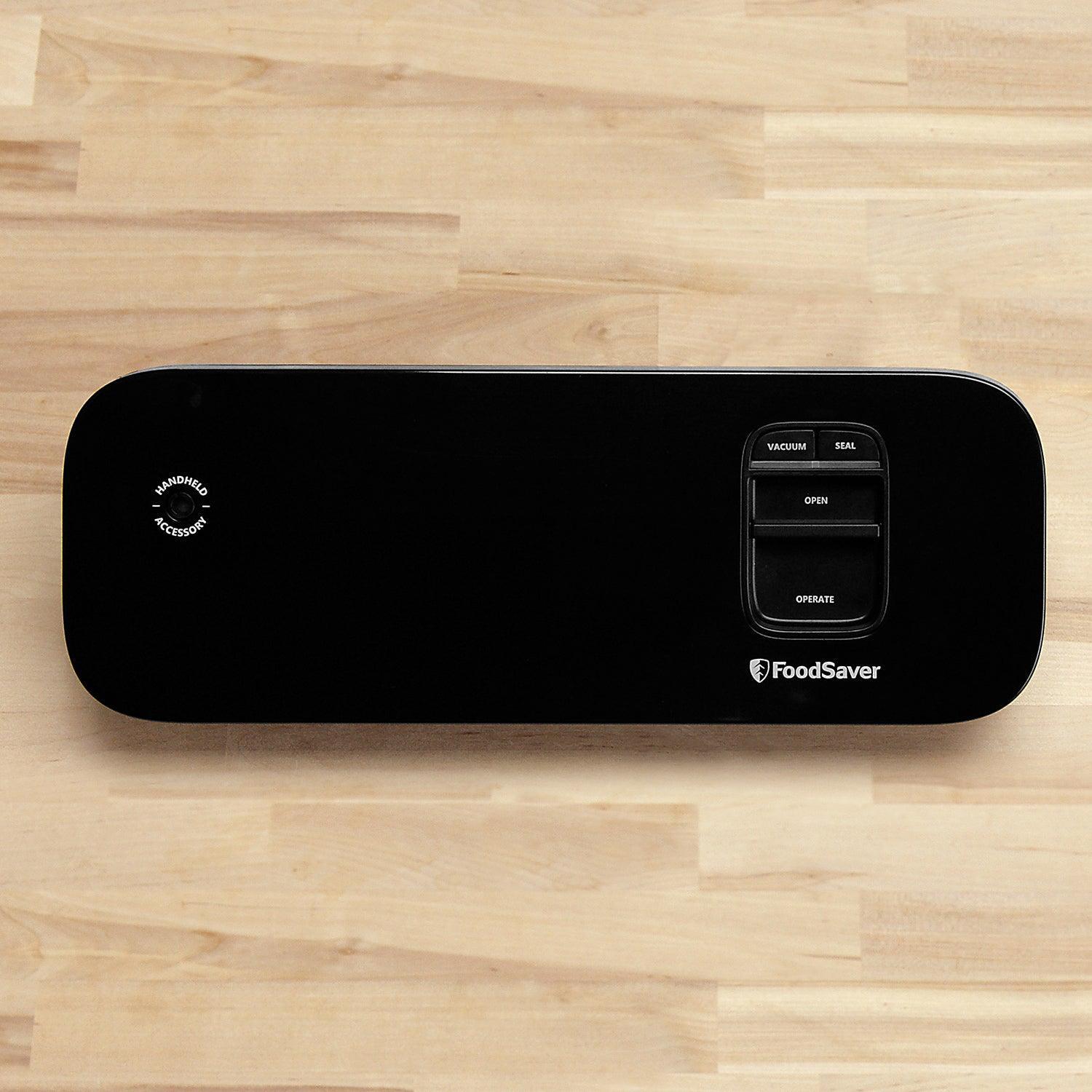 FoodSaver vacuum sealer in black on wooden surface with control buttons visible