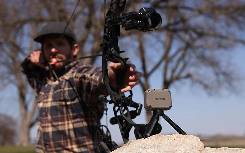 Garmin Xero C1 Pro chronograph on tripod with archer aiming bow outdoors