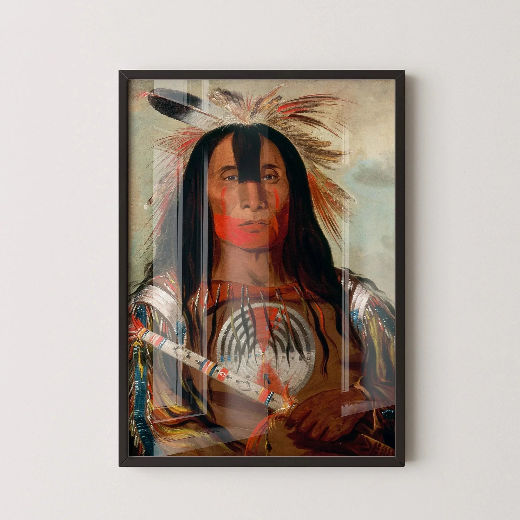 Framed Native American portrait with feather headdress, face paint, and colorful attire on wall