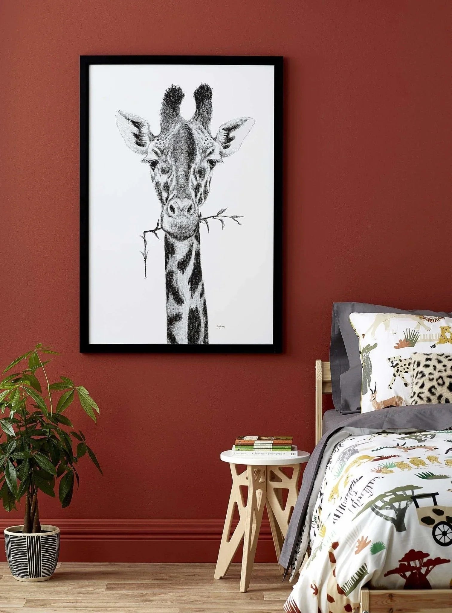 Giraffe portrait wall art in a modern bedroom with rust-colored wall and botanical decor