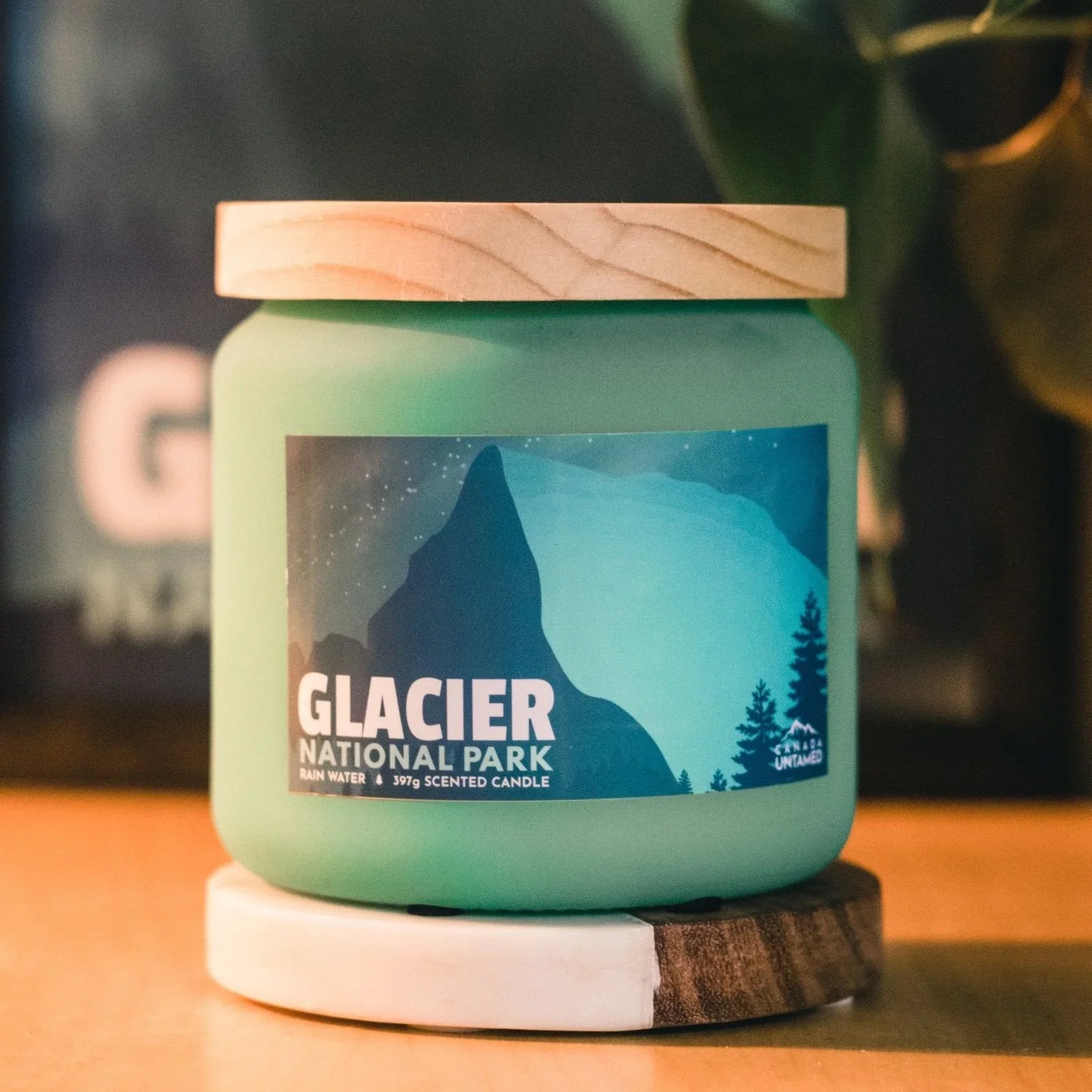 Glacier National Park rain water scented candle with mountain label on wood surface