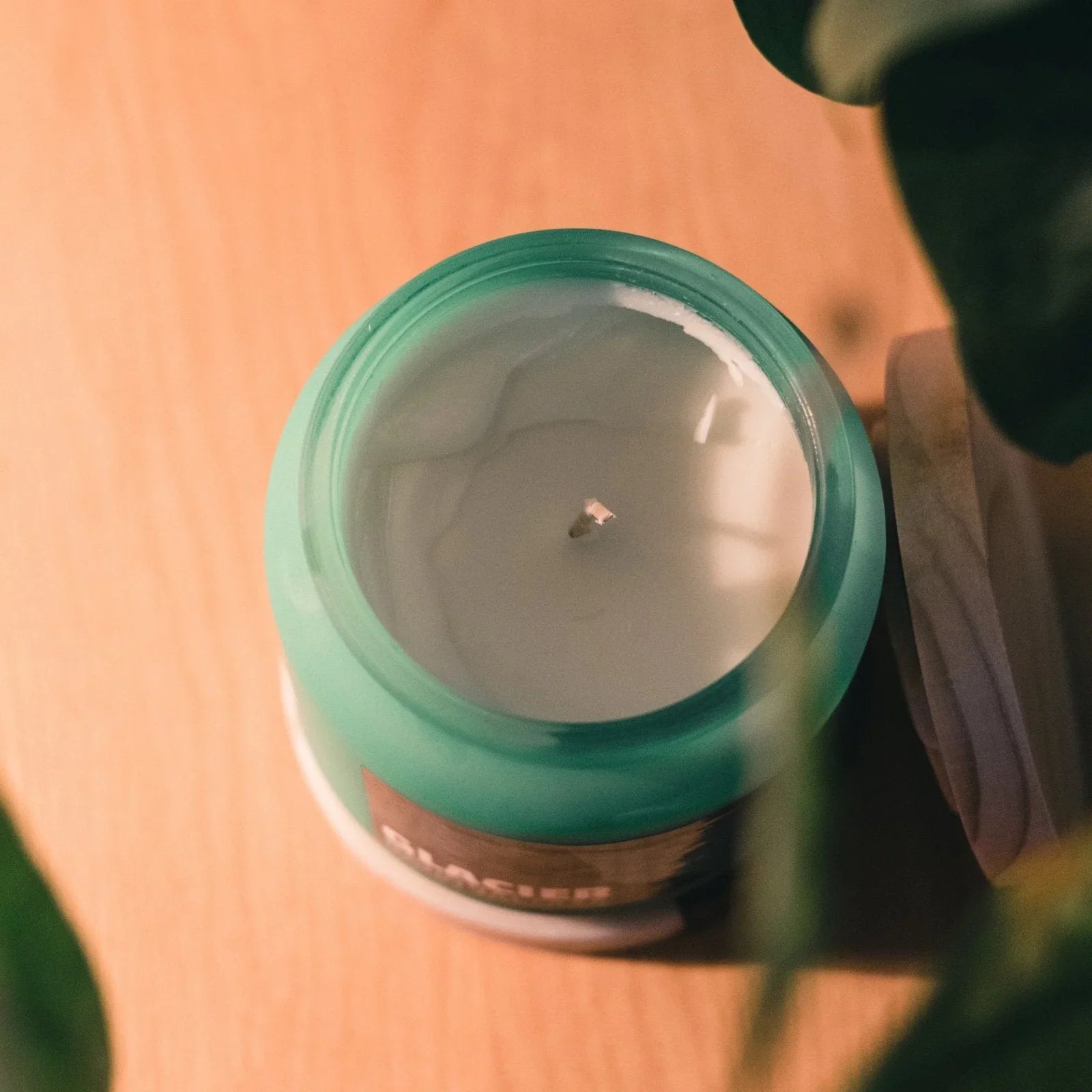 Glacier National Park rain water scented candle in green jar on wooden surface