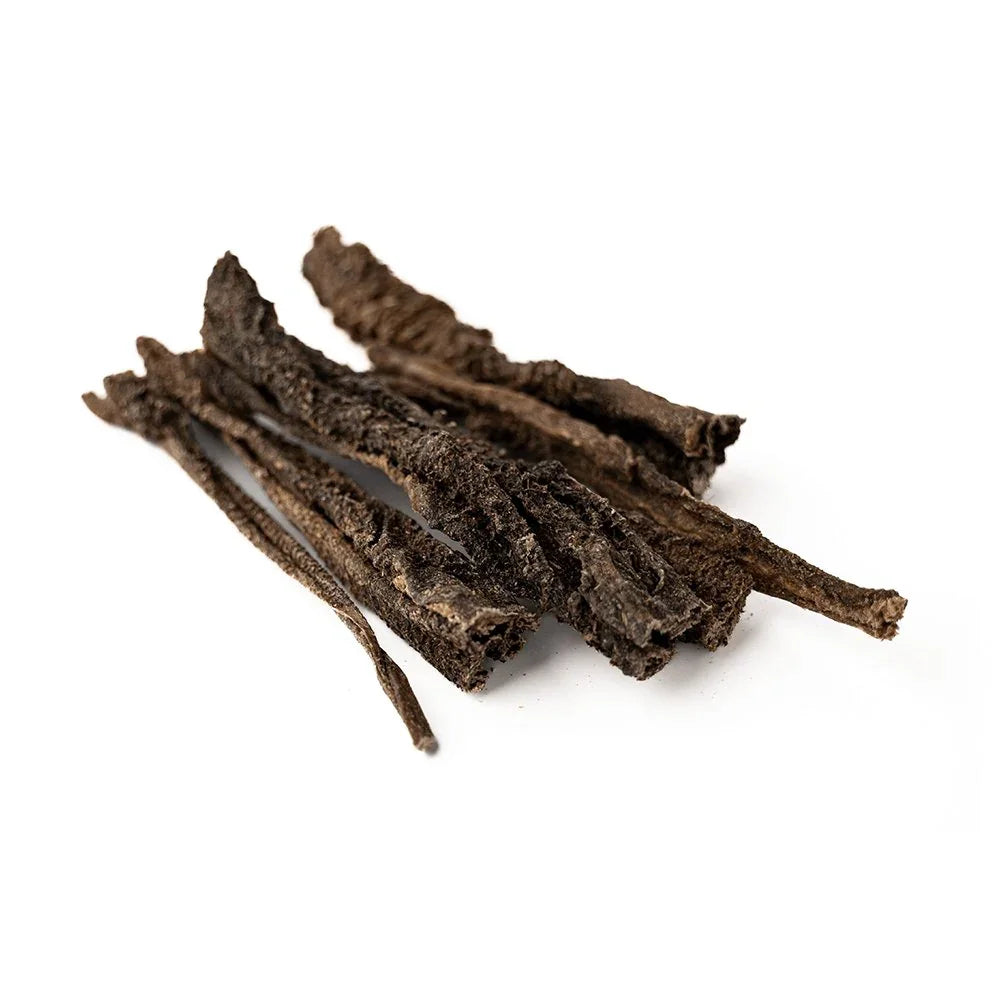 Dried green lamb tripe dog treats on a white background