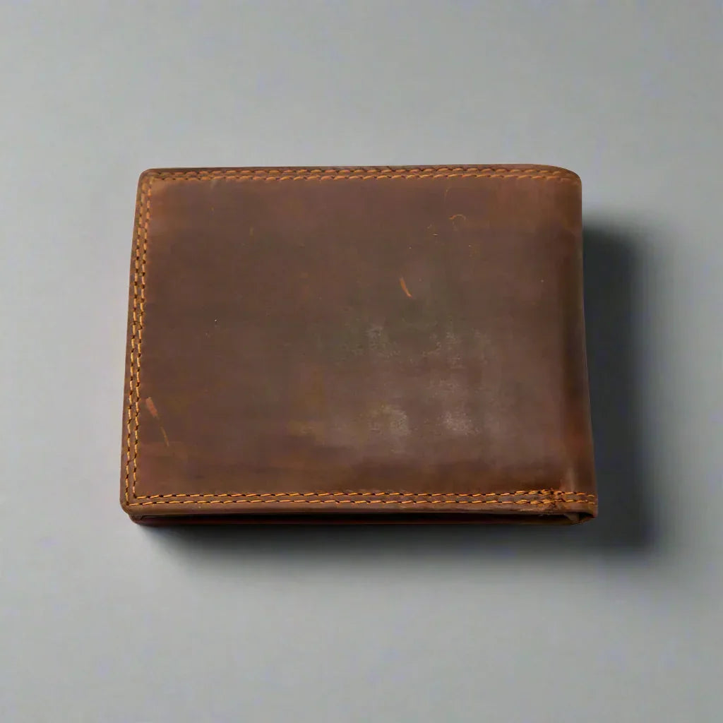 Brown leather wallet with visible stitching on a plain gray background