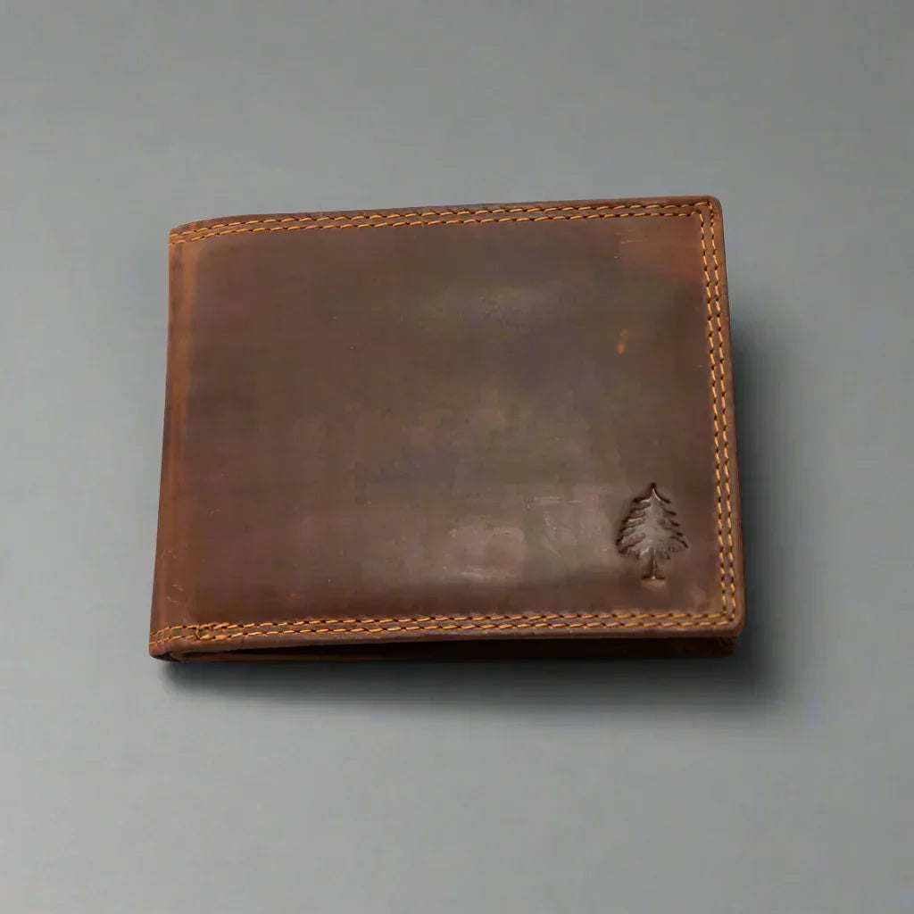 Brown leather wallet with tree embossing and tan stitching on a gray background