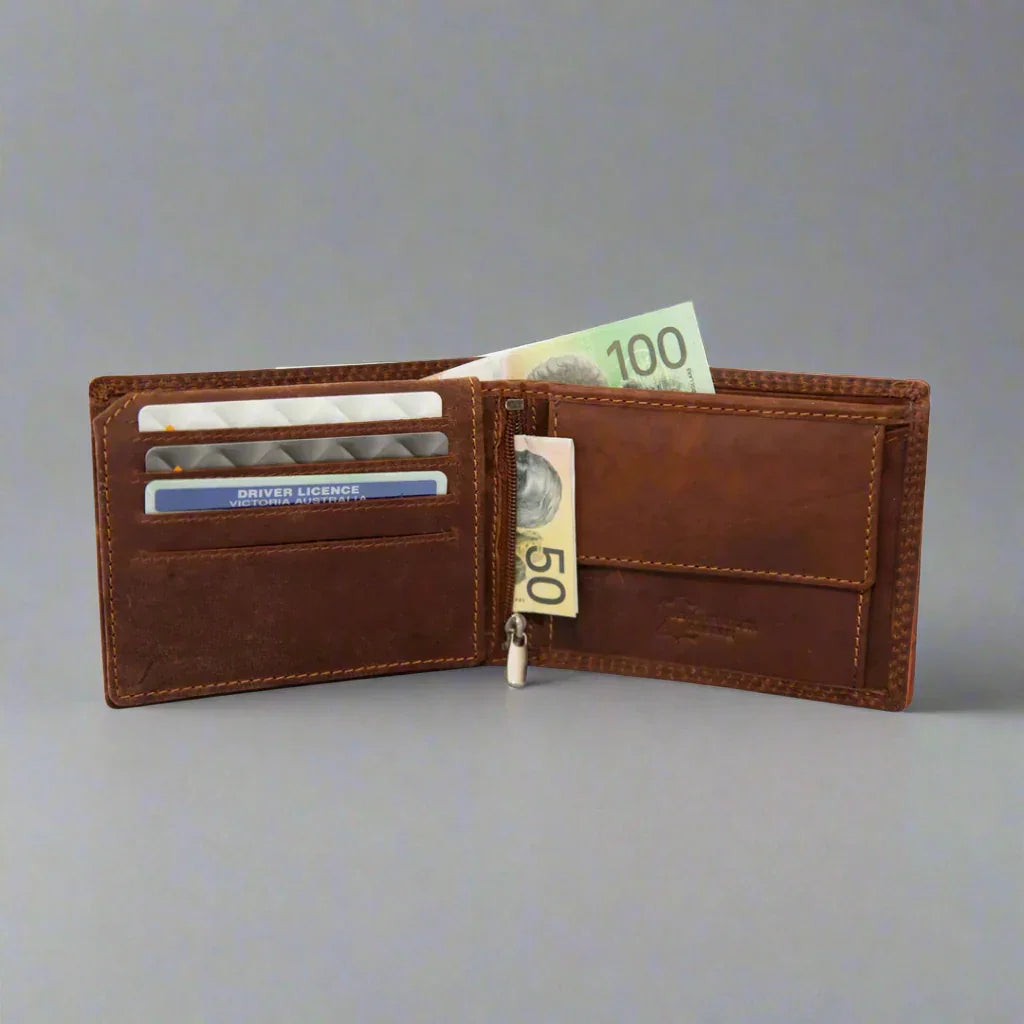 Open brown leather wallet with banknotes, cards and license on grey background