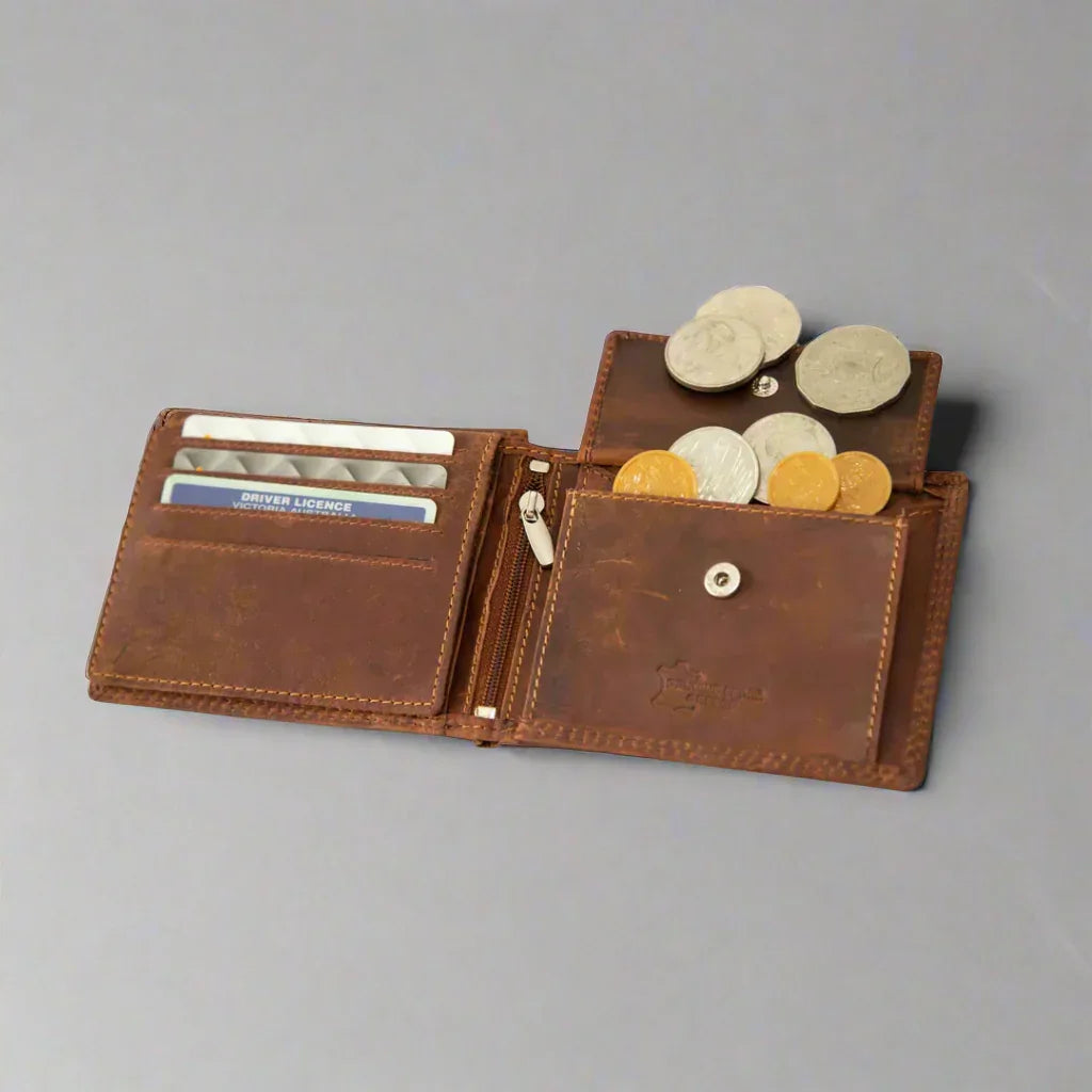 Open brown leather wallet with coins and cards displayed on a gray background