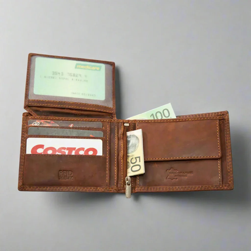 Open brown leather wallet with cards and Australian cash on a gray background
