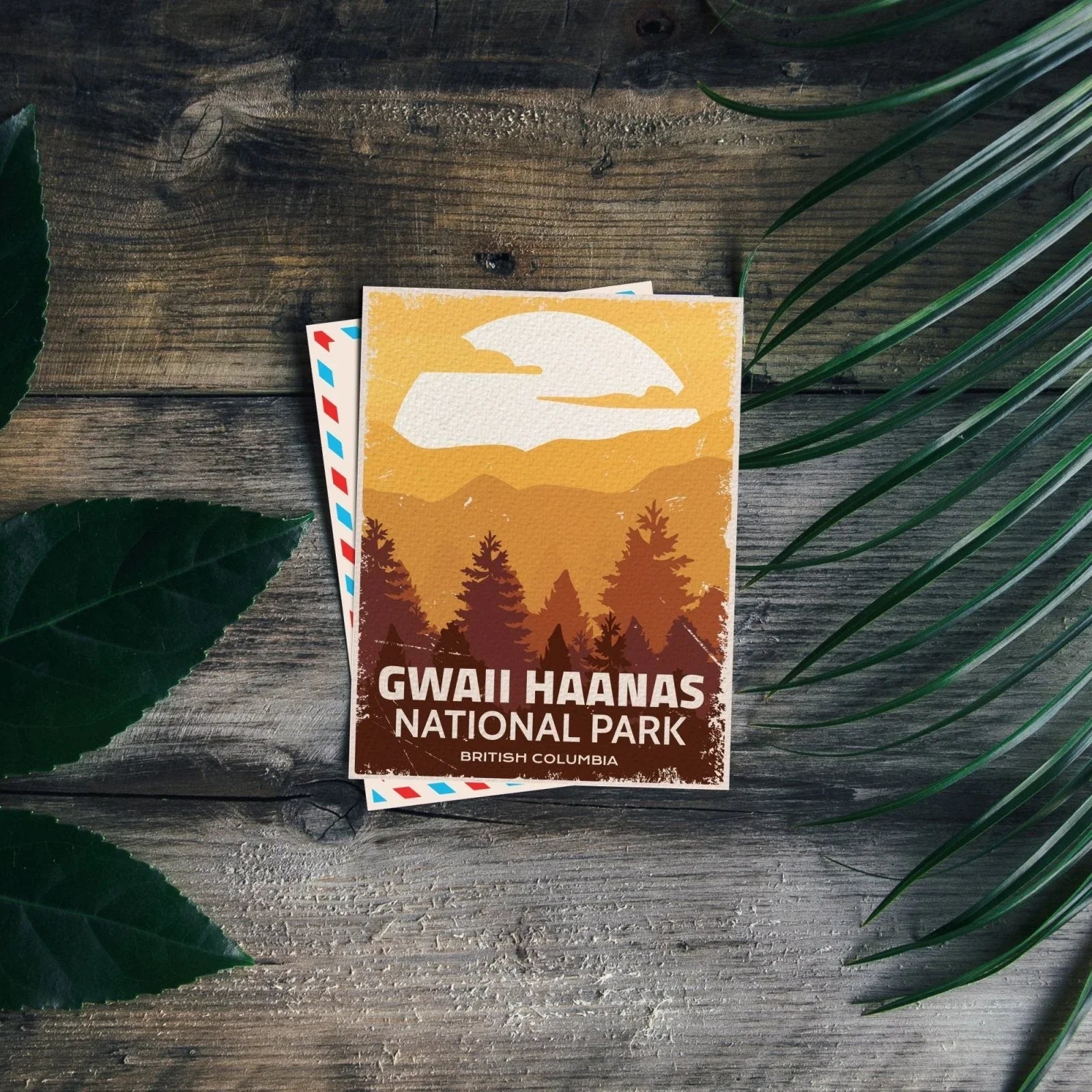 Gwaii Haanas National Park postcard on rustic wood with green leaves, British Columbia