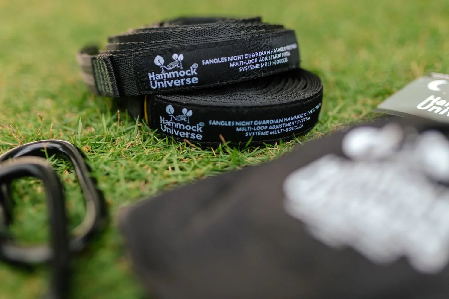 Hammock Universe black multi-loop tree straps on grass, outdoor hammock gear.