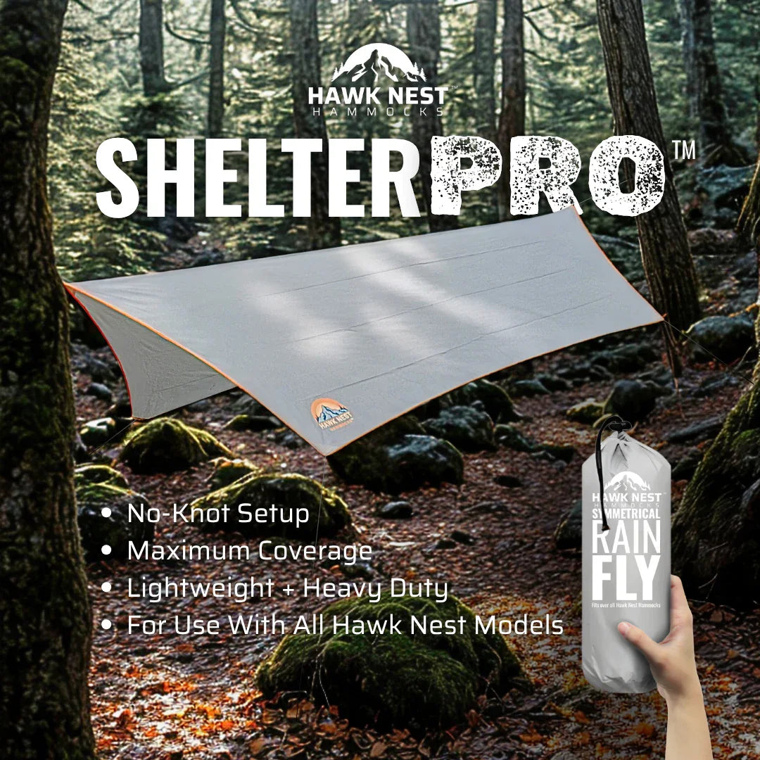 Hawk Nest Shelter Pro tarp set up in forest, hand holding packaged rain fly, camping gear