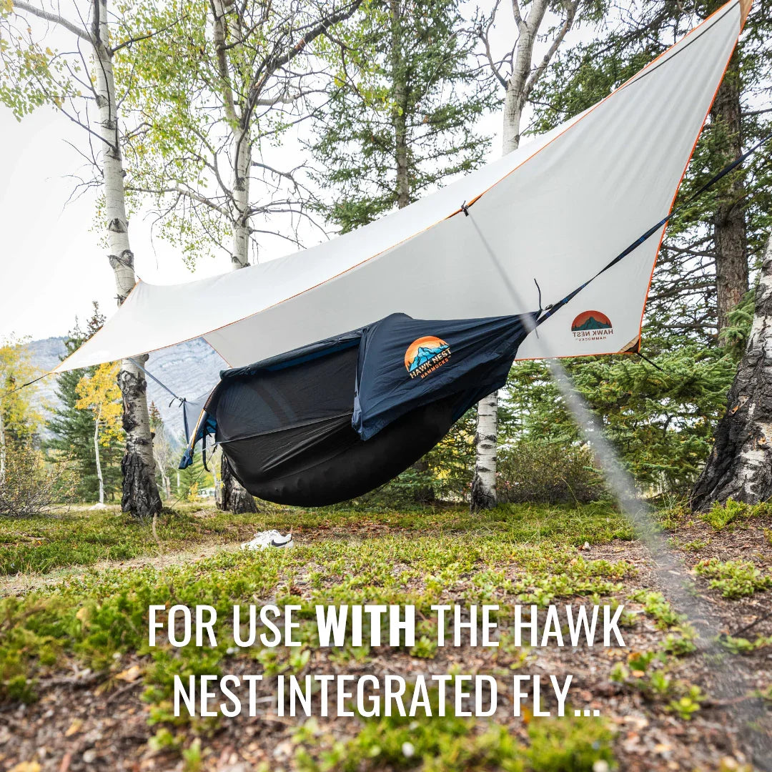 Hawk Nest hammock tent with integrated fly set up between trees outdoors
