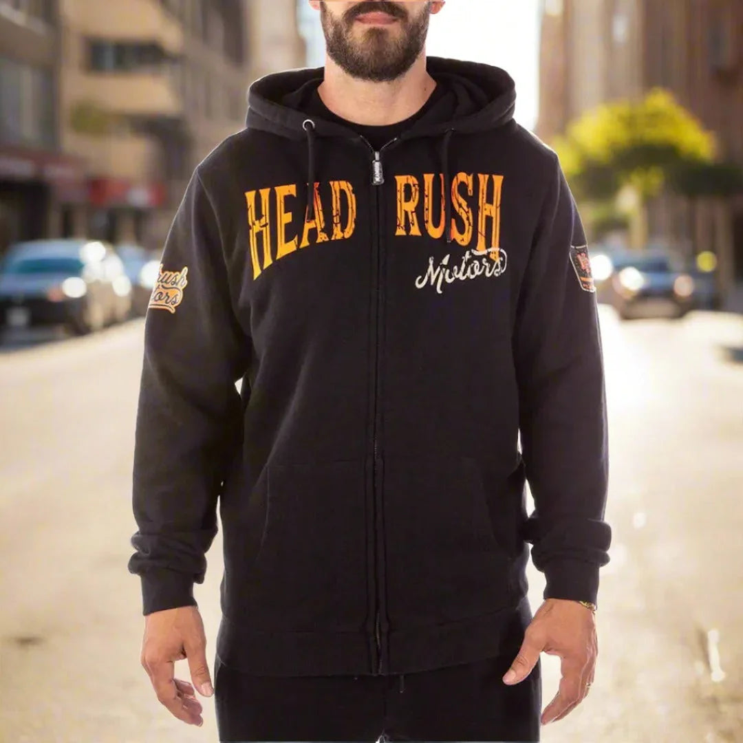 Man wearing Headrush men's black zip-up hoodie with bold yellow lettering outdoors.