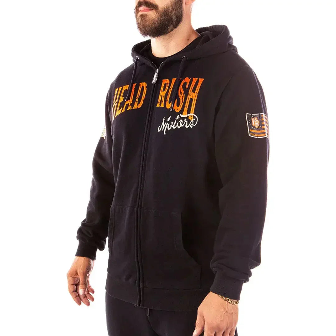 Man wearing black Headrush Mechanic zip-up hoodie with orange lettering and patch sleeve detail