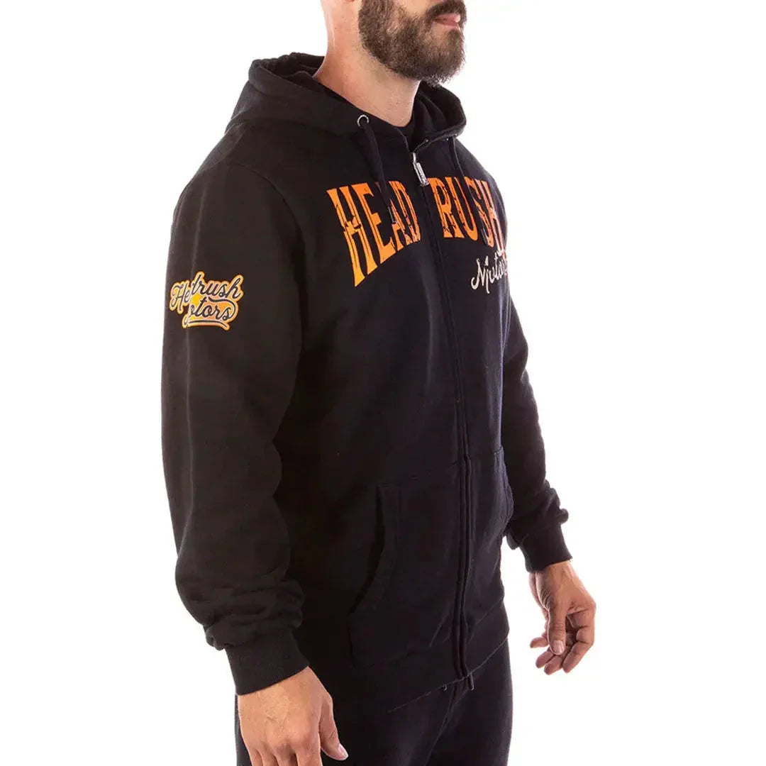 Man wearing Headrush The Mechanic black zip-up hoodie with orange logo print