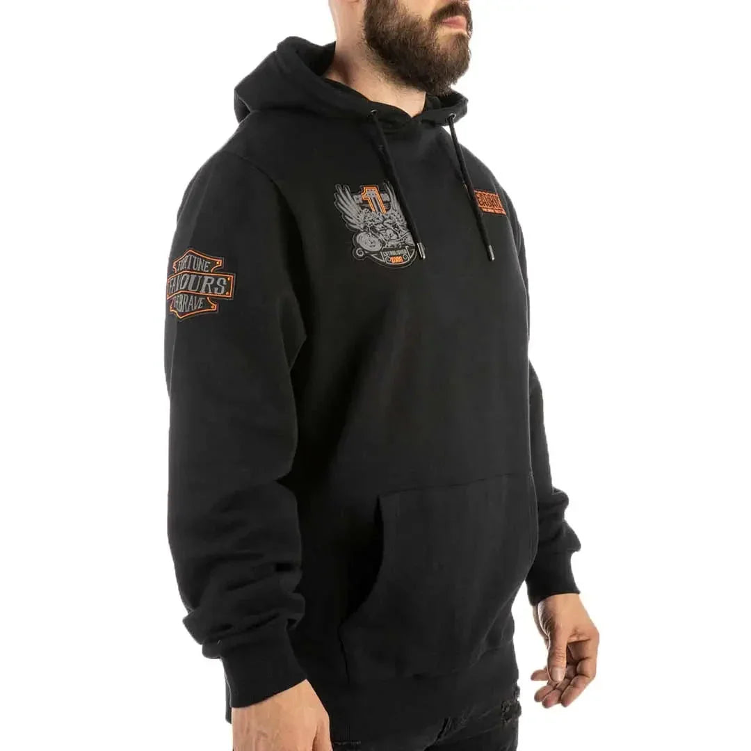 Man wearing black Headrush Worldwide pullover hoodie with graphic patches and kangaroo pocket