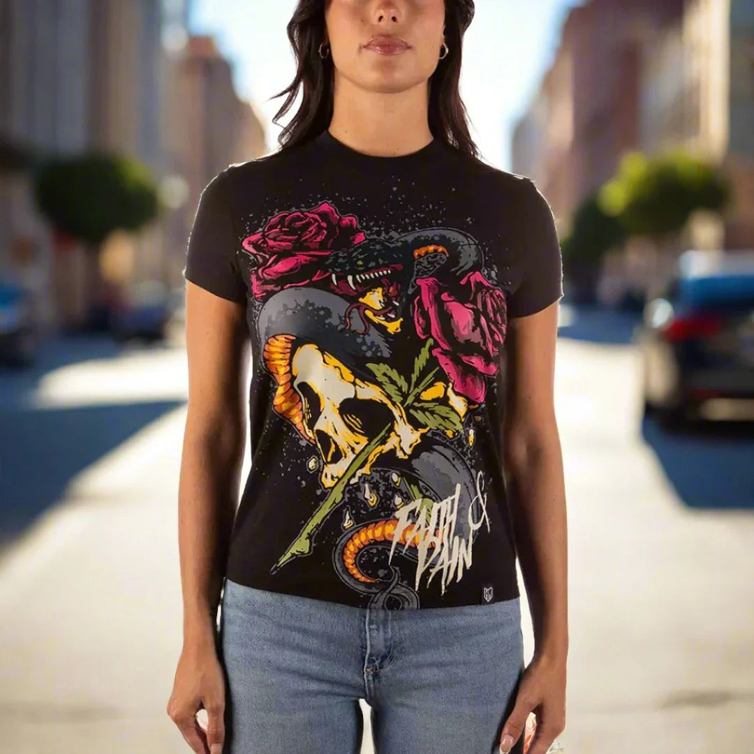Woman wearing black graphic t-shirt with skull, roses, snake, and 'Faith & Pain' text outdoors