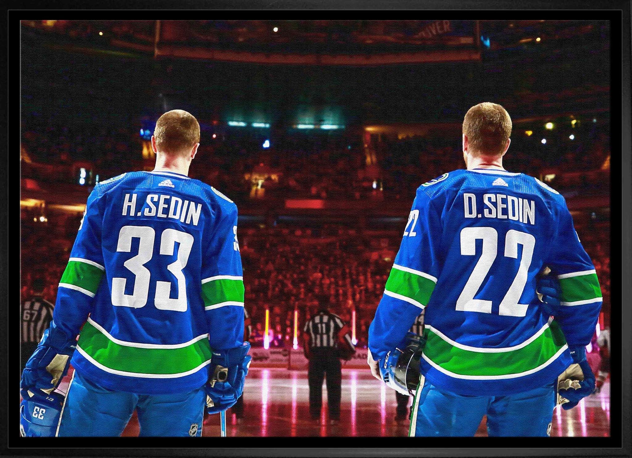 Two hockey players in blue, green, and white jerseys with names H. Sedin and D. Sedin on ice rink