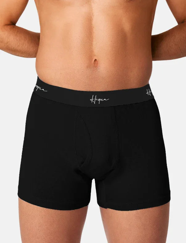 Man wearing black Hiqua boxer briefs with logo waistband against a plain background