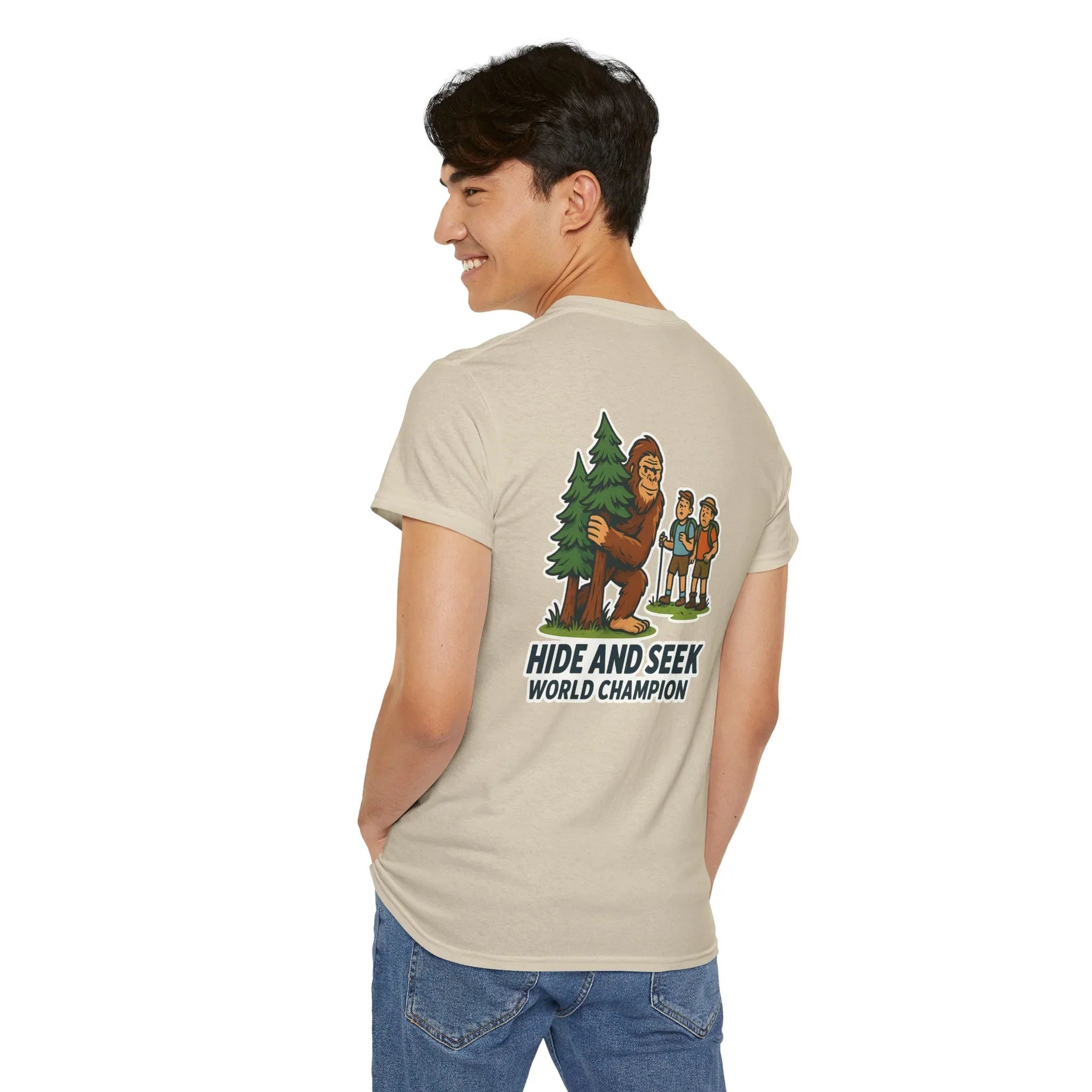 Man wearing beige t-shirt with Bigfoot Hide and Seek World Champion graphic design