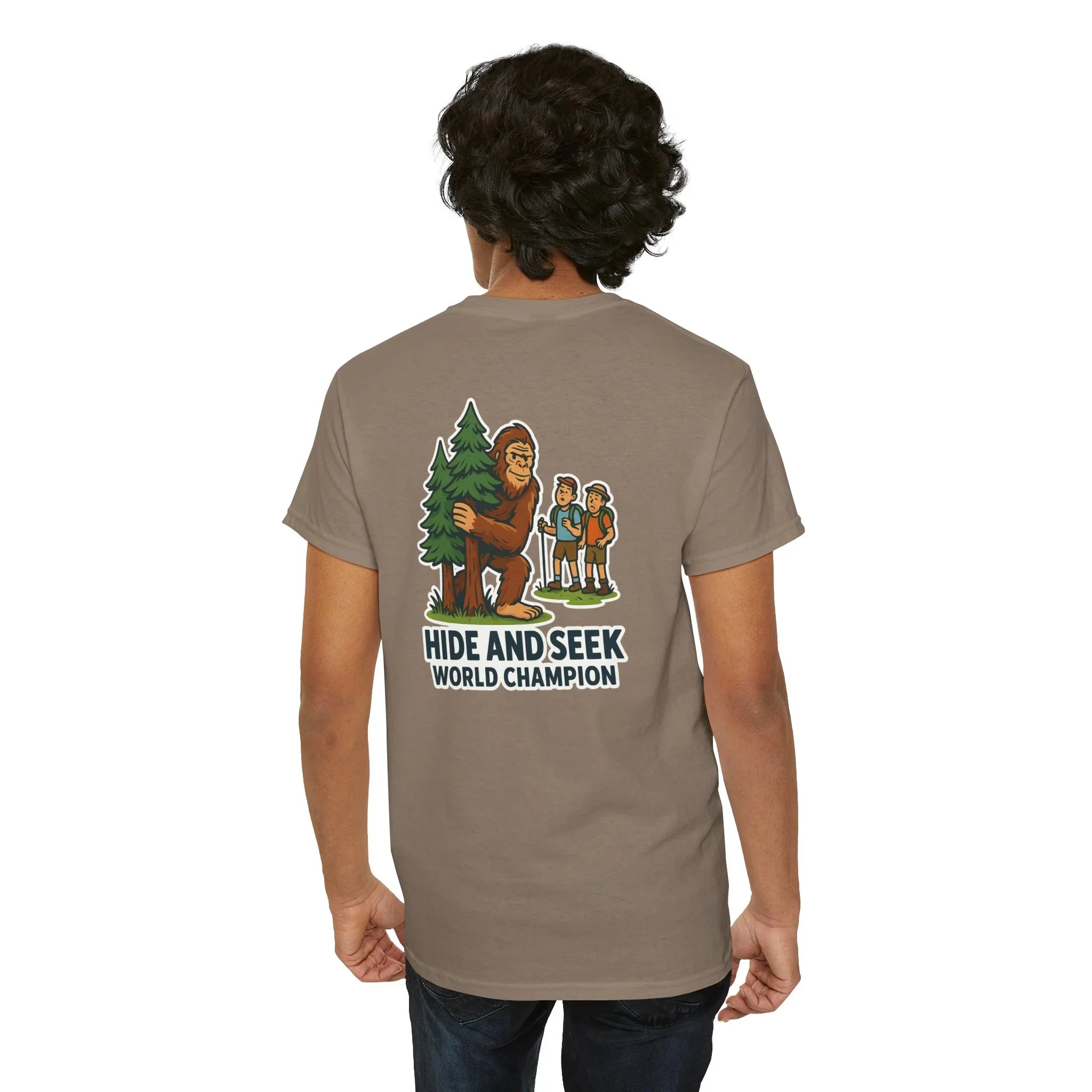 Man wearing khaki t-shirt with Bigfoot hide and seek world champion graphic and hikers