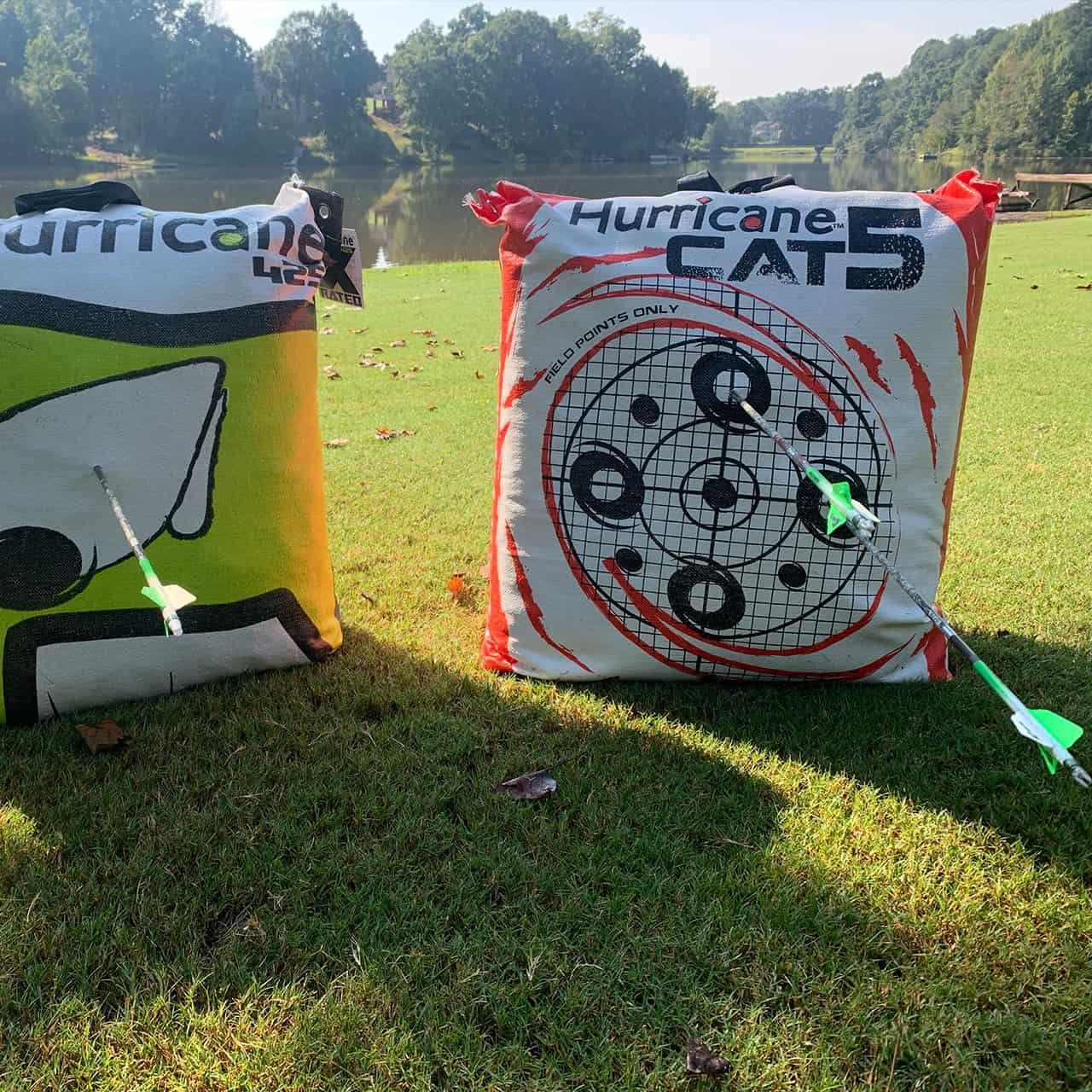 Hurricane Cat 5 archery bag target with arrows on grassy field by a lake