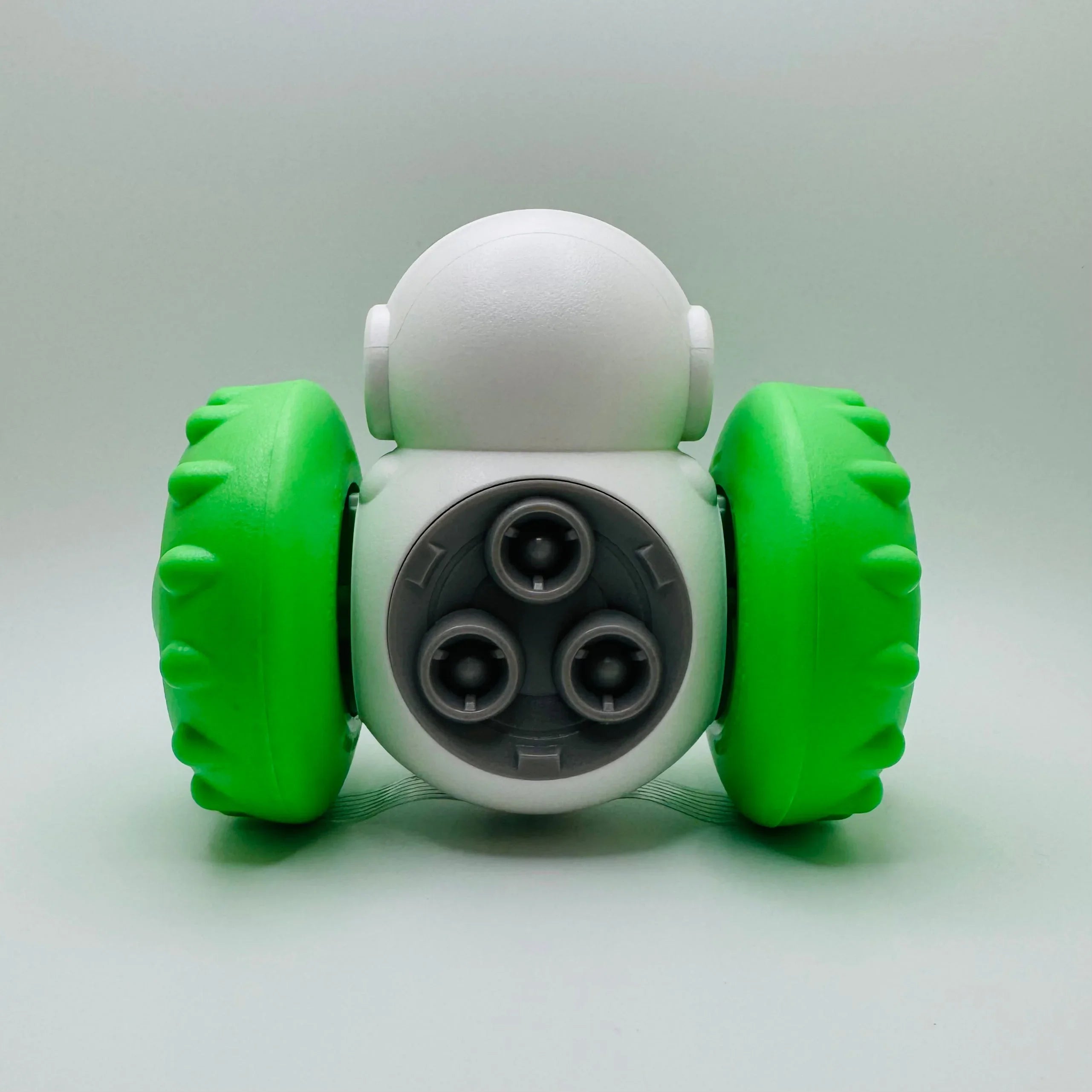 Interactive pet toy robot with green wheels and three launcher openings on white background