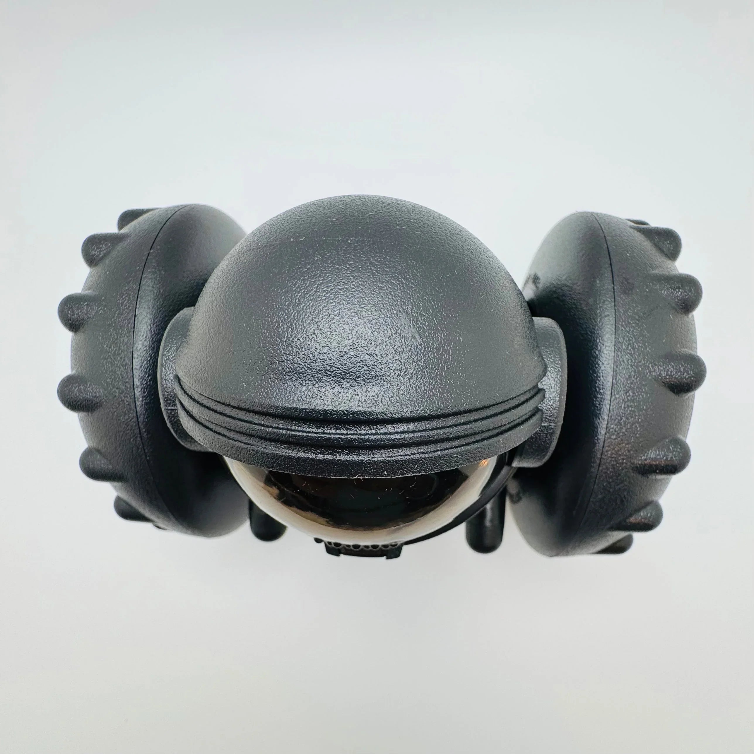 Black robotic pet toy with dual rugged wheels and dome-shaped body on white background