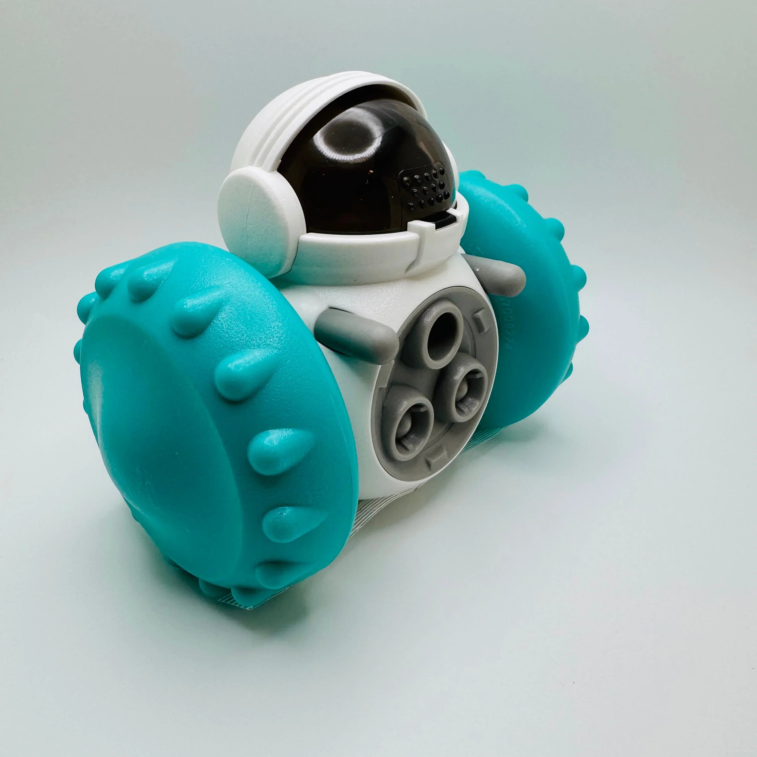 Robot dog toy with spiked blue wheels and astronaut helmet design on white background