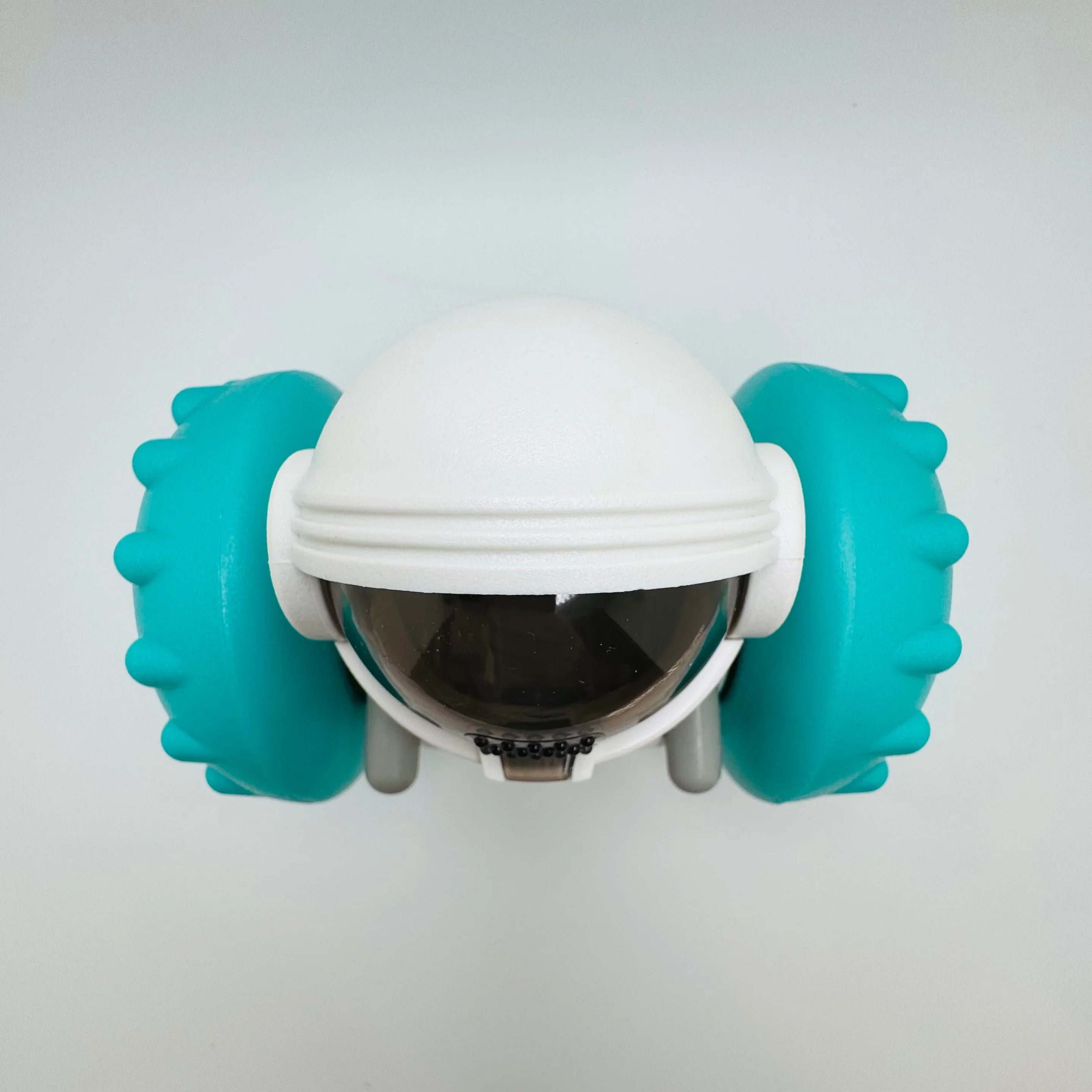 Cute astronaut-themed dog toy with blue rubber spikes and a white helmet on plain background