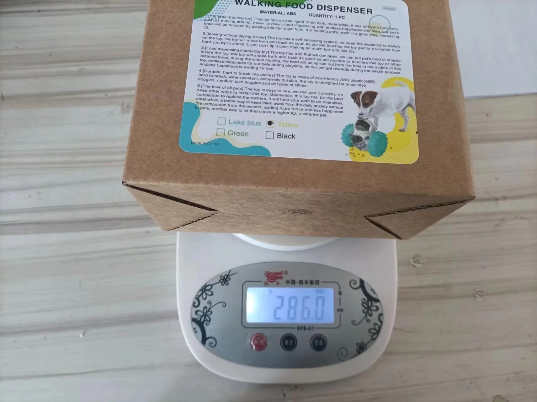 Dog walking food dispenser box on digital scale reading 286.0 grams, product label visible