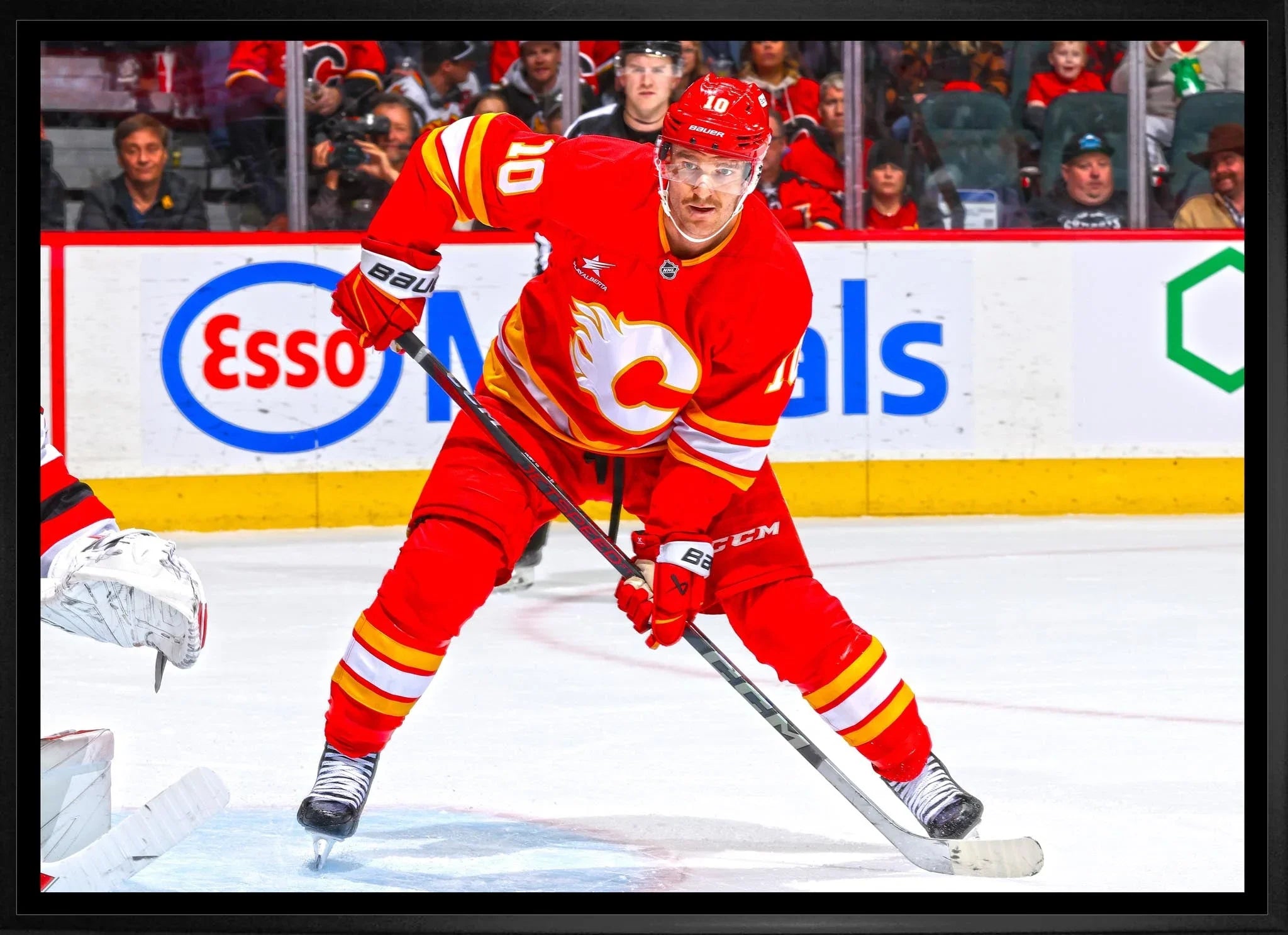 Calgary Flames hockey player in red jersey skating on ice during game action