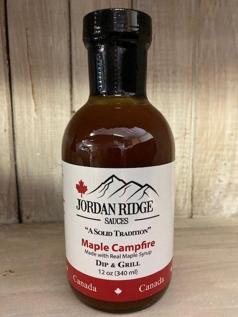 Jordan Ridge Maple Campfire sauce bottle, made with real maple syrup, on wooden background.