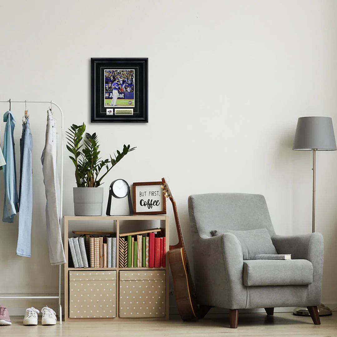 Modern living room with gray armchair, framed sports photo, bookshelf, and indoor plant