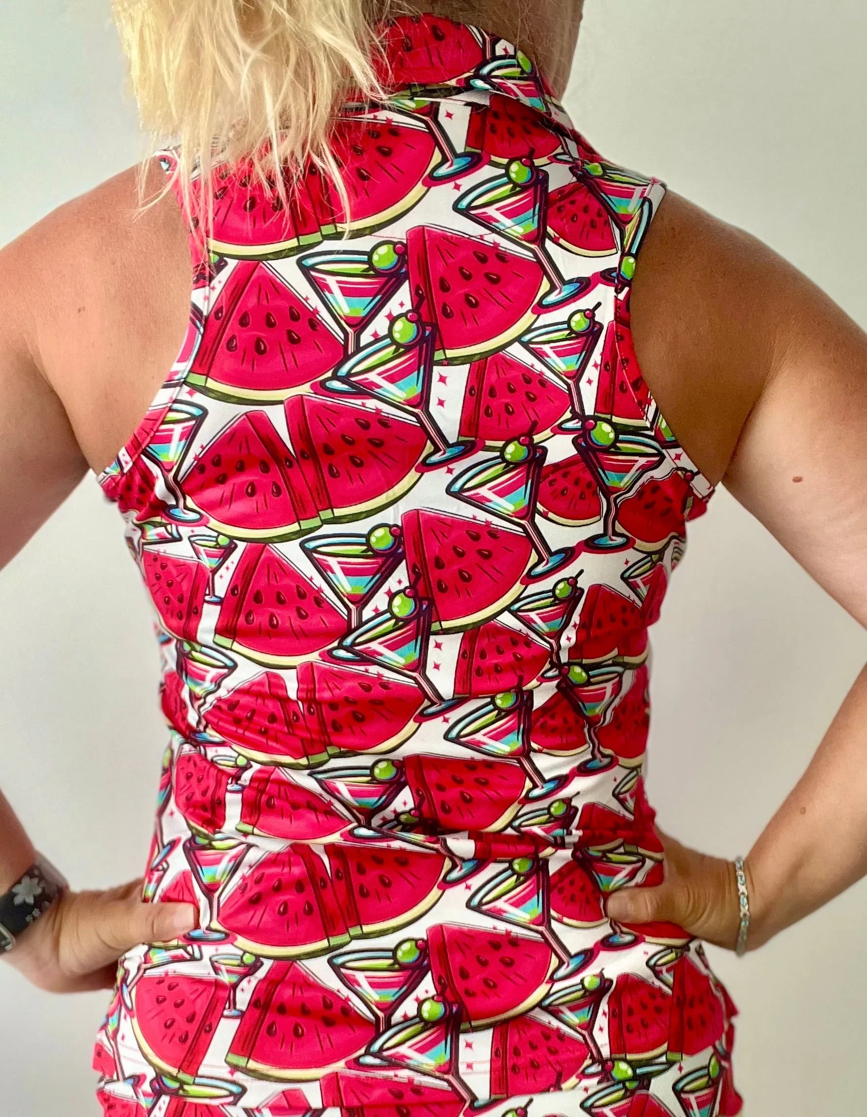 Back view of woman wearing sleeveless shirt with watermelon and cocktail print pattern