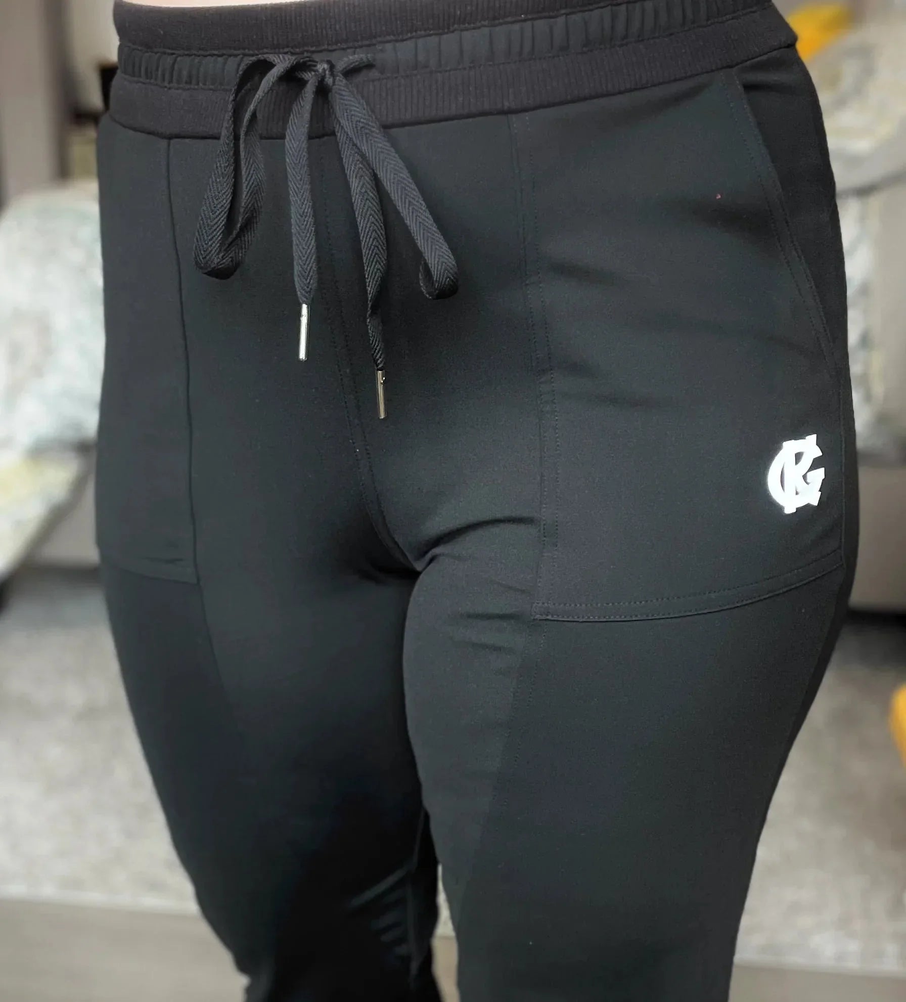 Black jogger pants with drawstring and white CG logo on side pocket