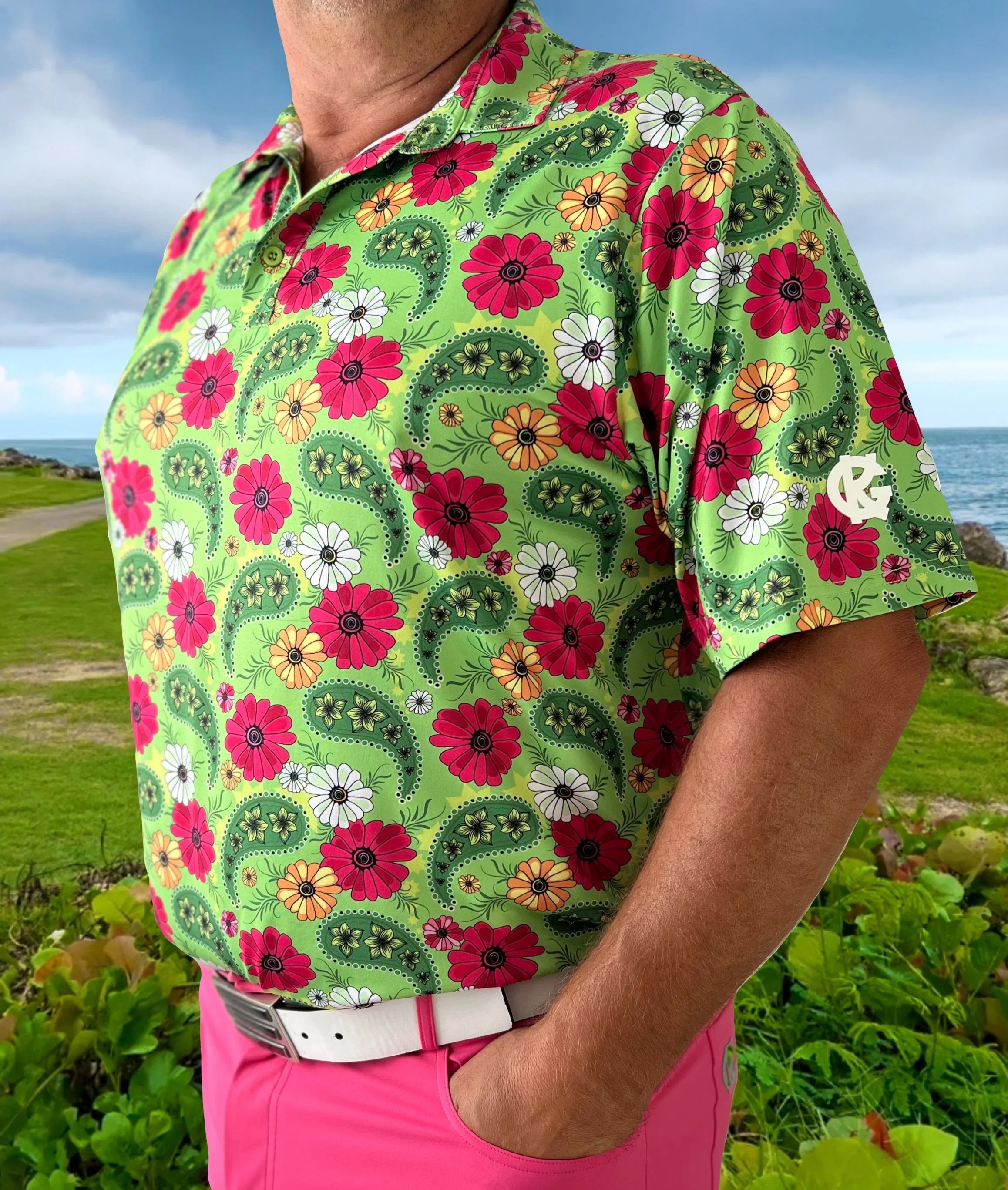 Man in green floral golf shirt and pink pants on a scenic coastal golf course
