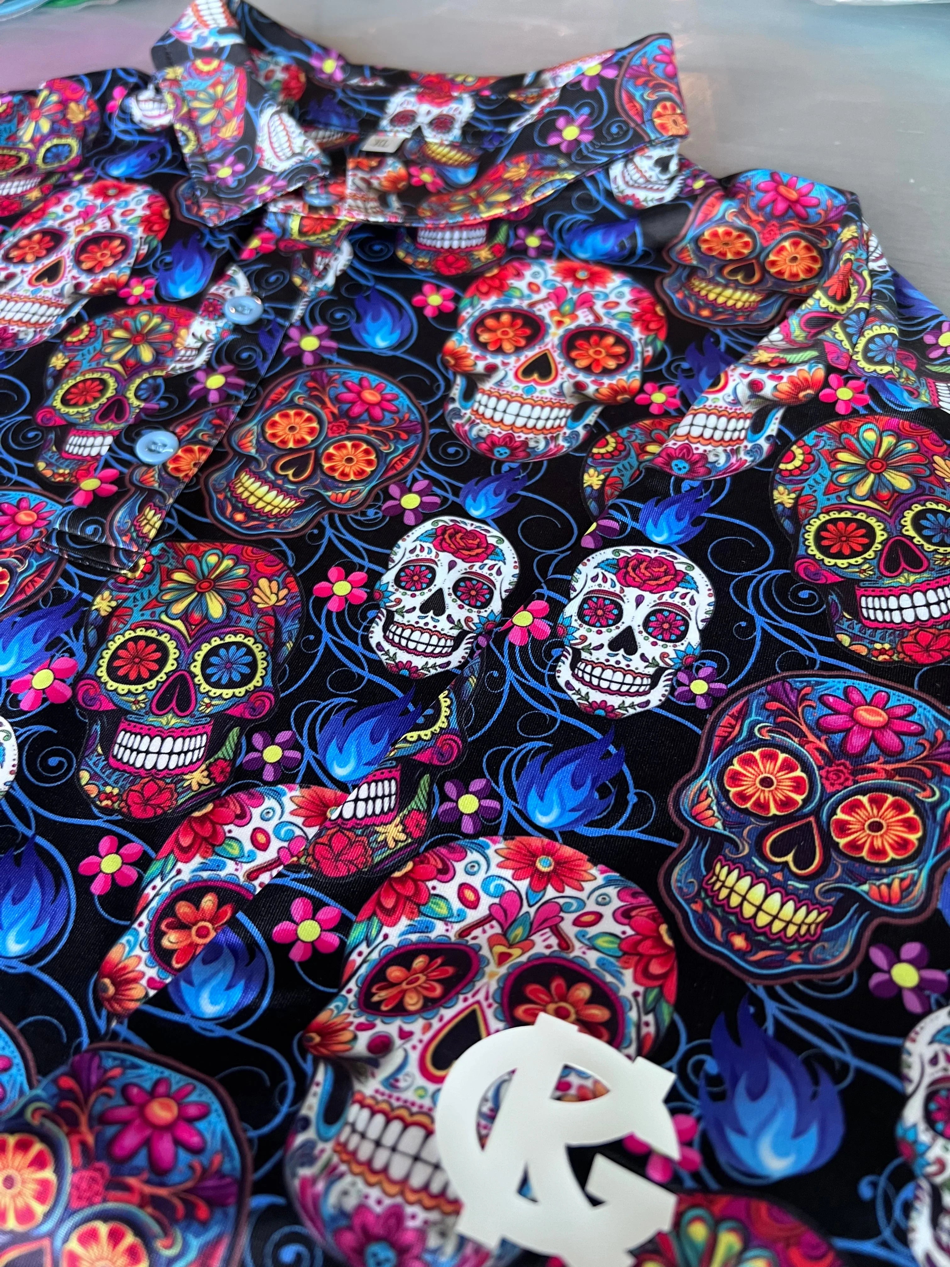 Colorful sugar skull button-up shirt with floral patterns on black background