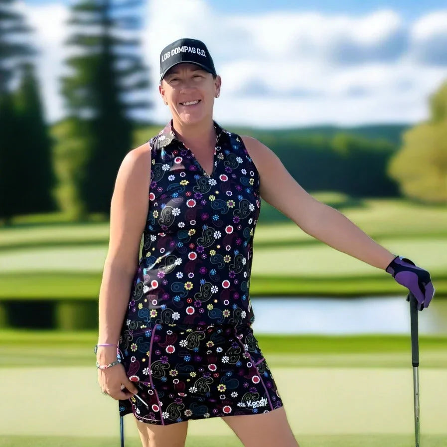 Woman golfer in floral sleeveless golf dress and cap smiling on a sunny golf course