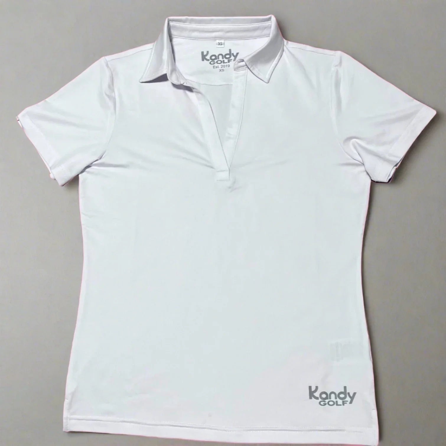 White Kandy Golf women's polo shirt with short sleeves and collar on gray background