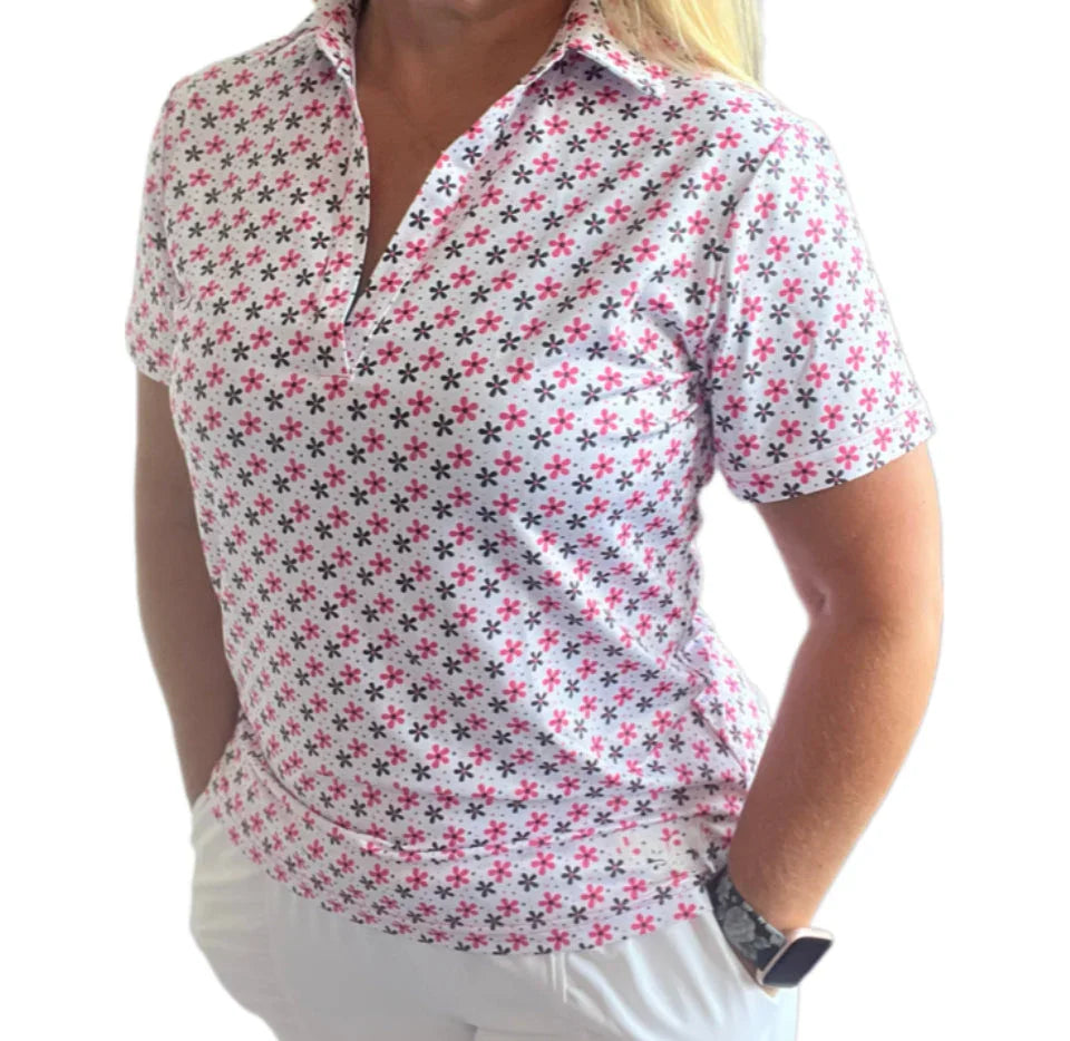 Woman wearing a white short-sleeve polo with pink and black floral pattern