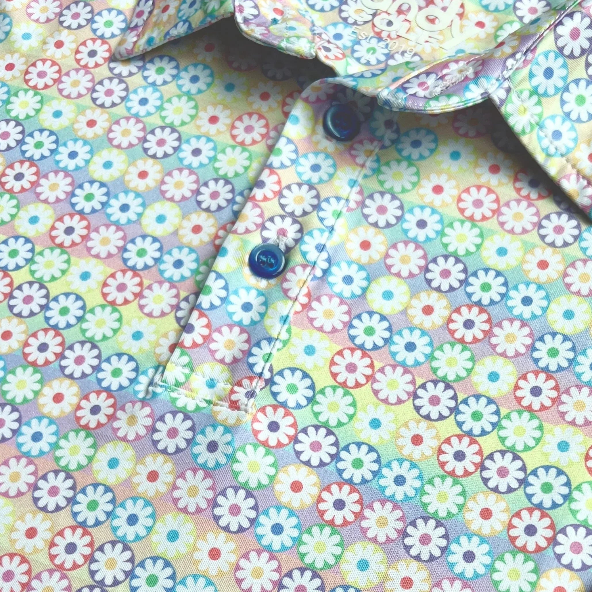Colorful floral print shirt with blue buttons and pastel daisy pattern