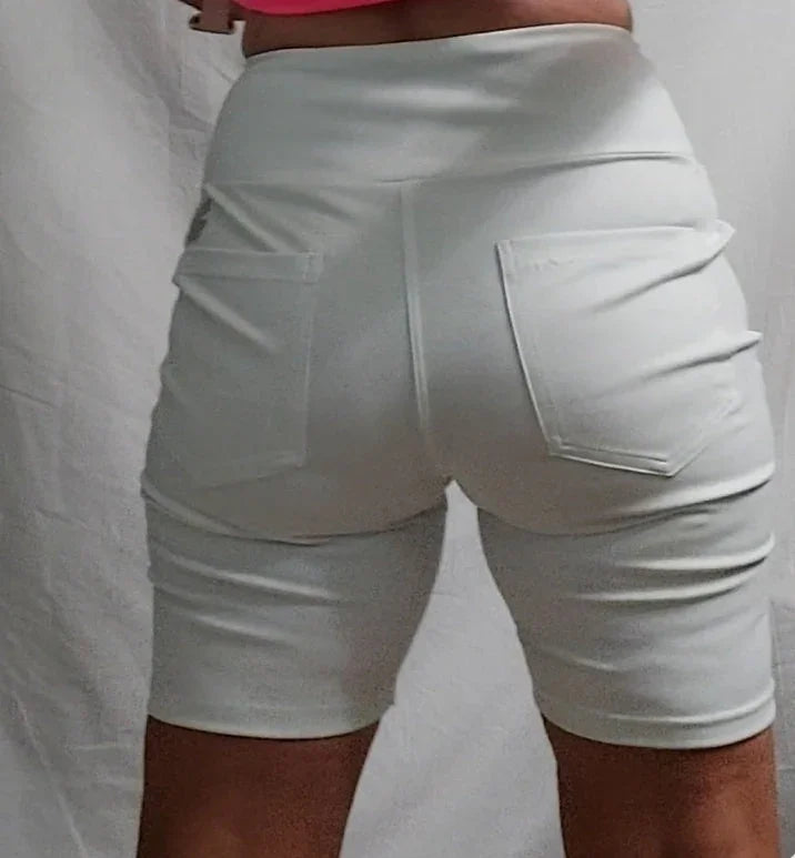 Back view of person wearing white high-waisted shorts with pockets against plain background