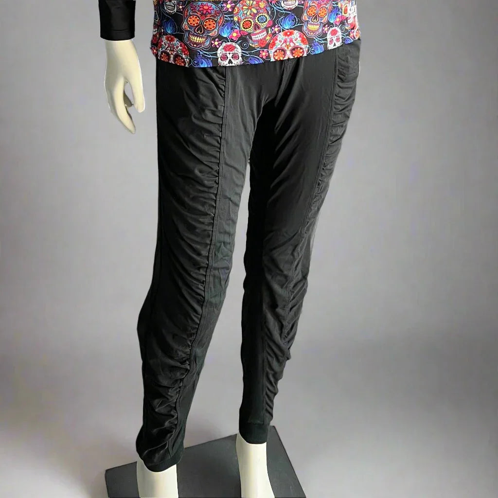 Black ruched jogger pants on mannequin, paired with colorful sugar skull top