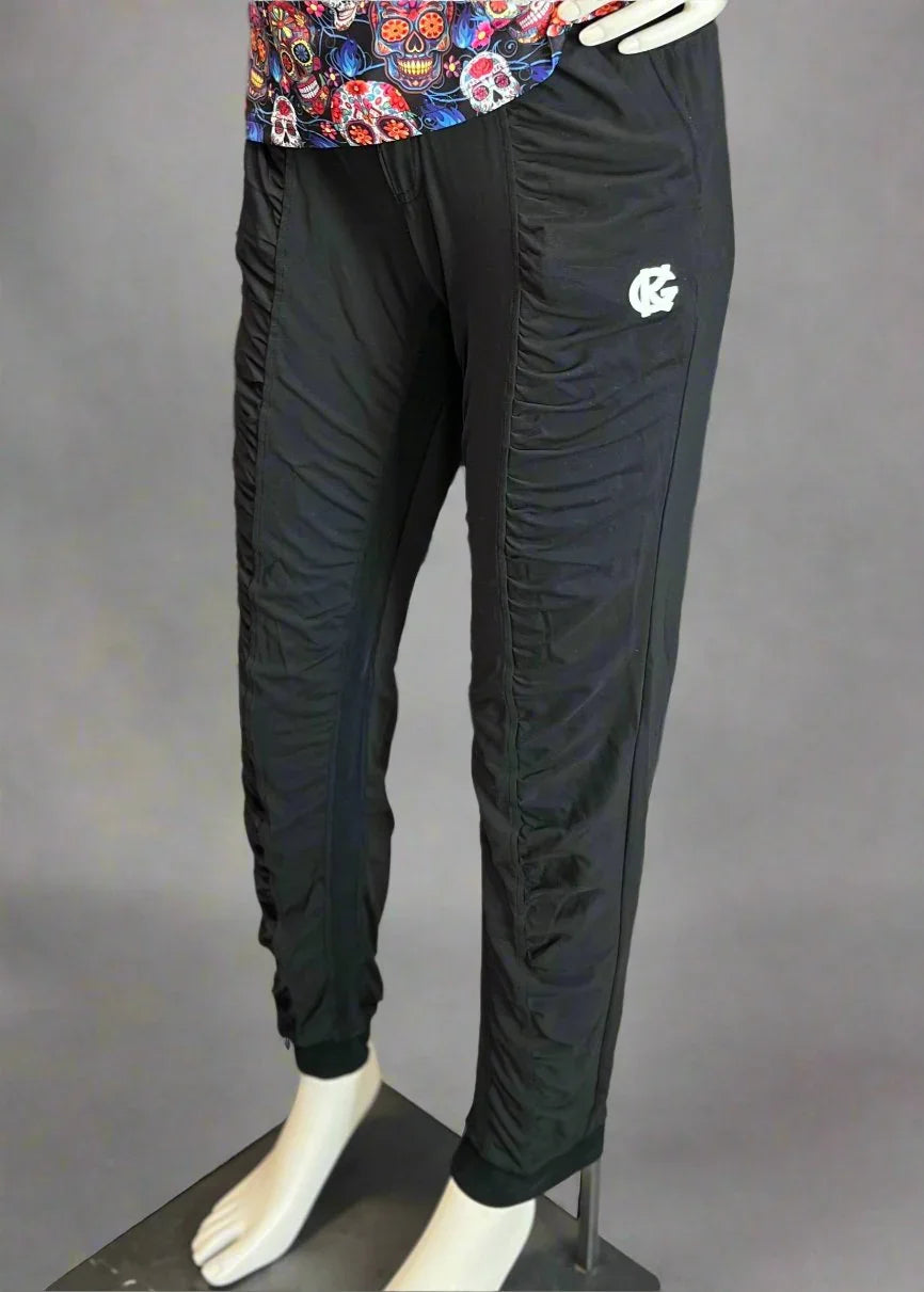 Black jogger pants with side ruching and white logo, shown on mannequin, grey backdrop