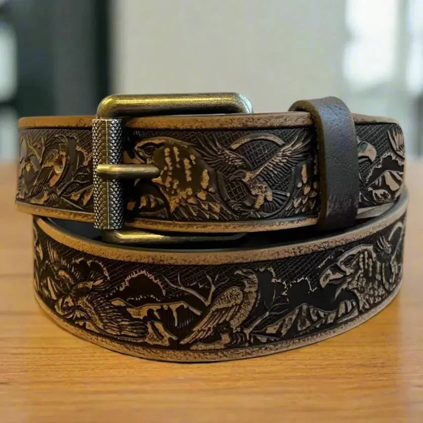 Brown grain leather men's belt with eagle embossing and removable metal buckle on table