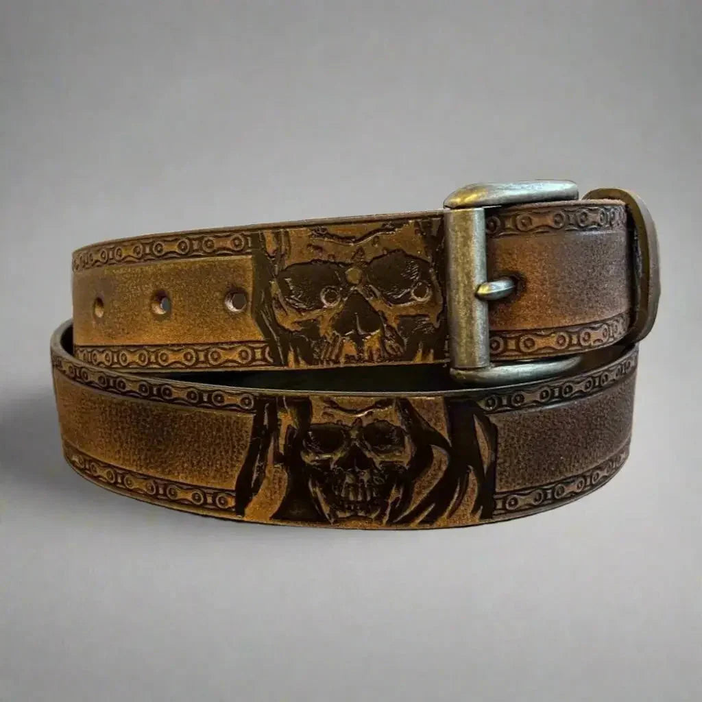 Brown grain leather men's belt with engraved skull design and metal buckle