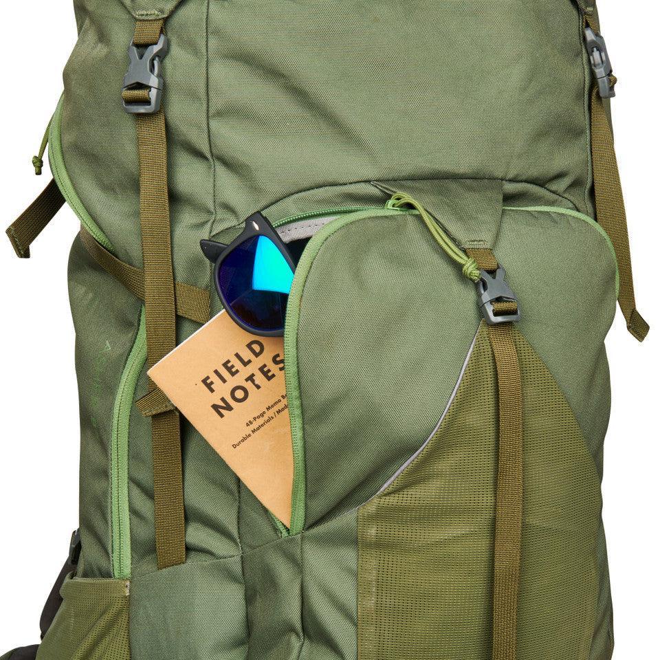 Green Kelty Asher 85 backpack with sunglasses and Field Notes in front pocket