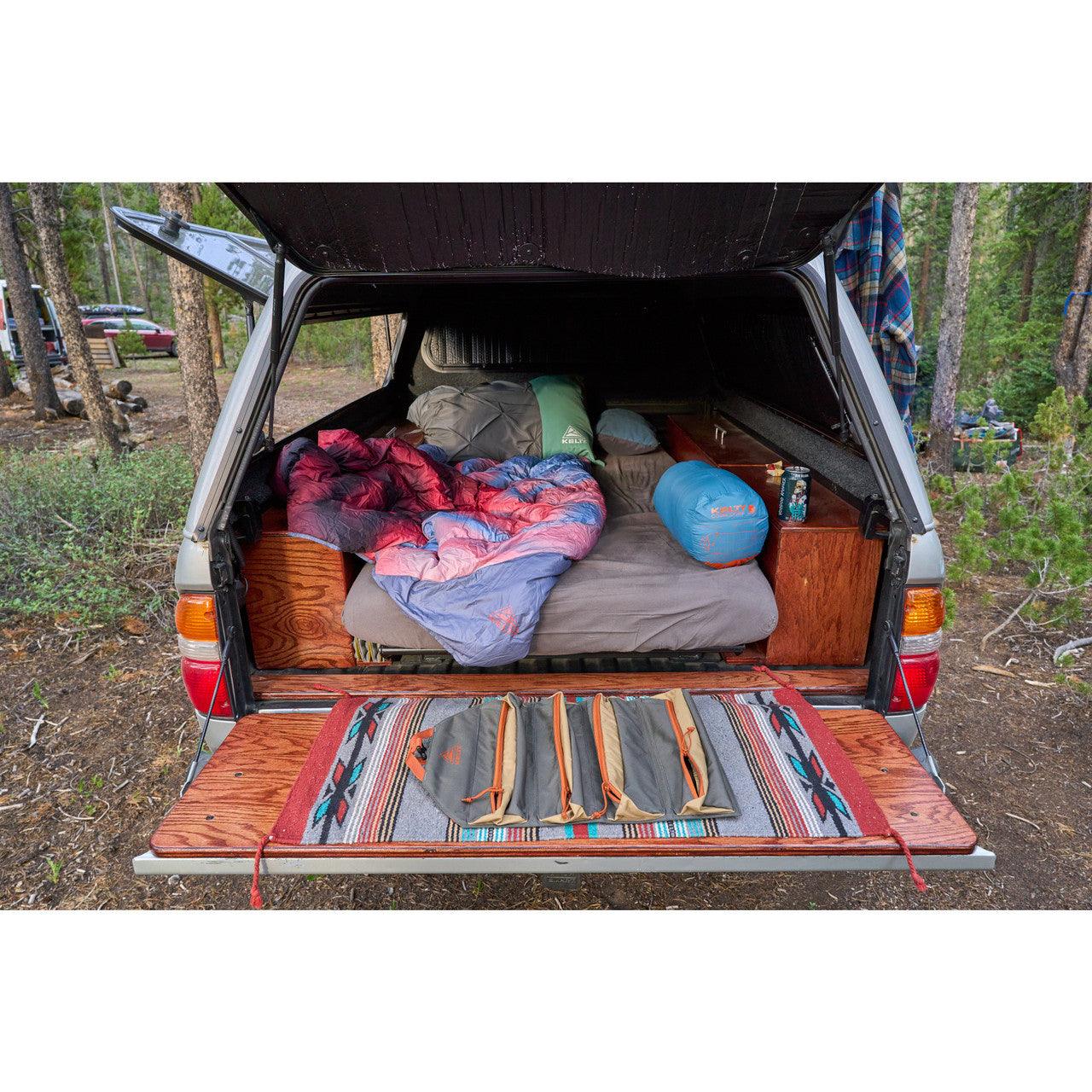 Chef knife roll in Beluga Dull Gold color displayed on tailgate at forest campsite